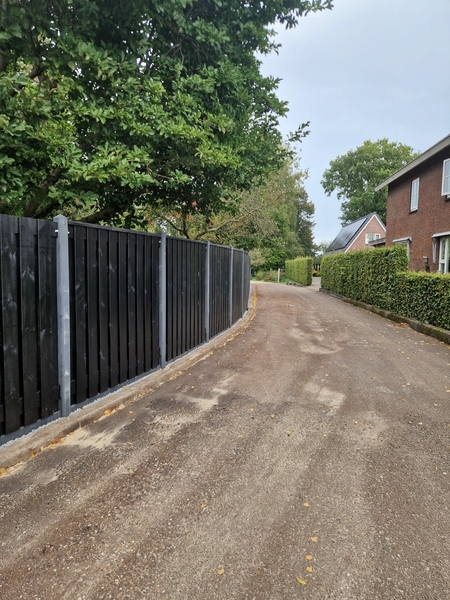 Hout-beton schutting met zwarte schuttingscherm door de bocht geleverd en geplaatst in Hoogeveen Drenthe